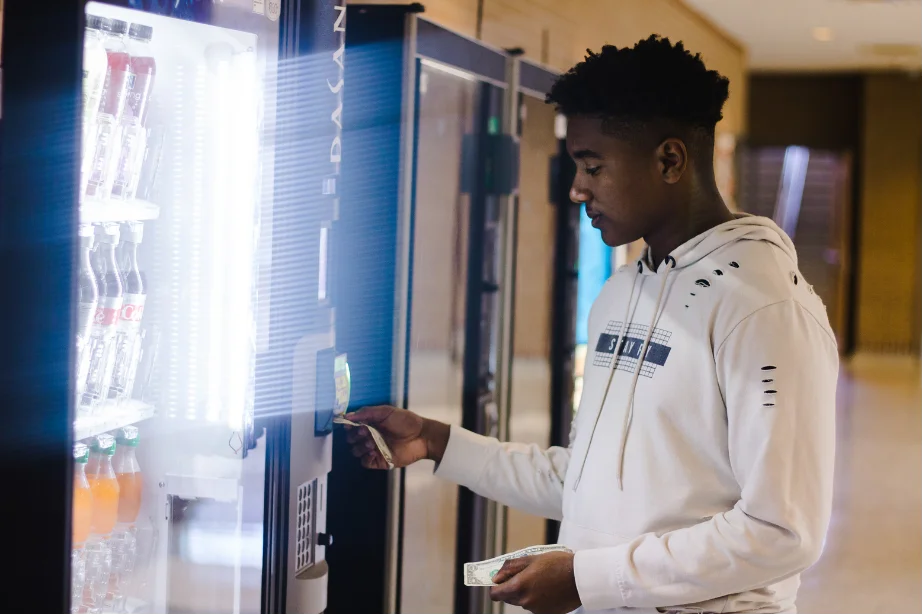 A Man Buying the products in vending mechine